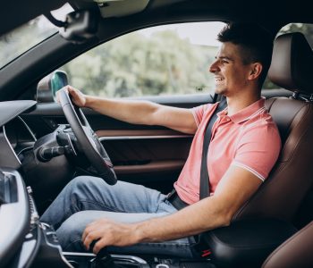 A smiling man driving a car, representing budget‑friendly car ownership and affordable car brands in Australia.