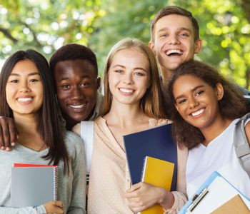 A group of international students stand together outside with notebooks and backpacks, symbolising the community of learners considering their Car Loan Options for International Students in Australia as they navigate financing choices while studying abroad