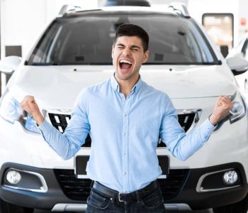 Excited man celebrating in front of a new car, illustrating that EOFY is the perfect time to rent-to-own your new car in Australia.
