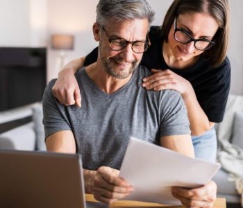 Two people reviewing financial documents, representing the New Financial Year focus on car payments and credit score management.