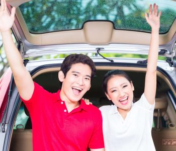 Two people standing beside cars, illustrating Car Loans Adelaide options and comparing traditional loans with flexible vehicle ownership solutions.