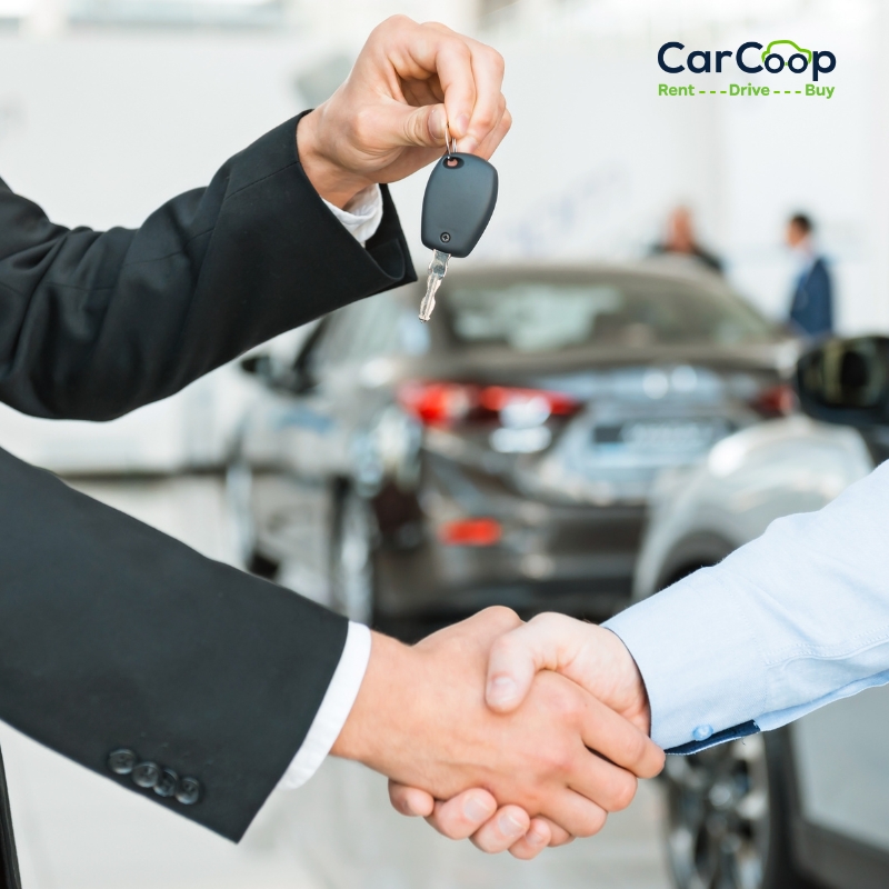 Handshake between two people as car keys are handed over at a dealership, representing a rent to own car Brisbane option.
