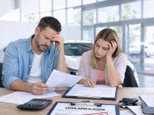 Credit score impact car finance applications in Queensland declined car loan couple reviewing rejected finance paperwork