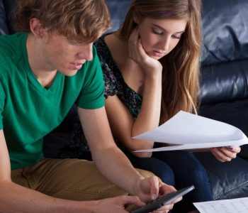 Young couple reviewing bills and finances while considering an income-based car lease option