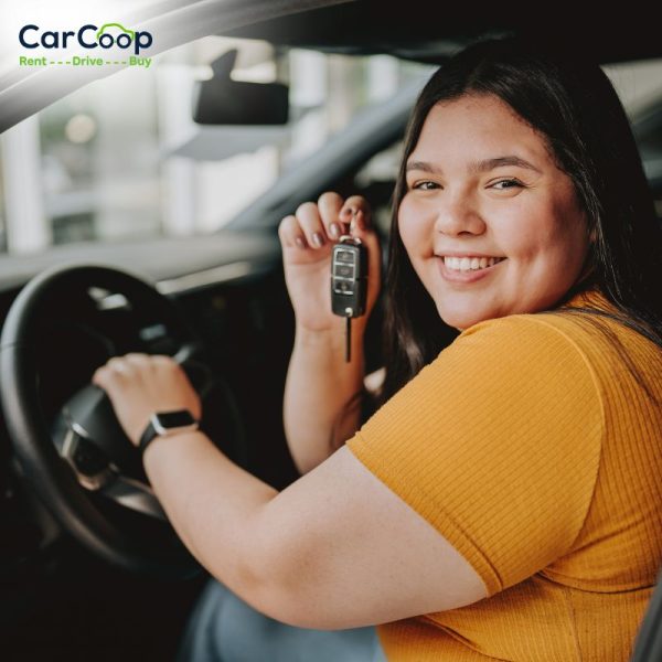 Smiling self-employed woman sitting in a car holding keys, representing car loans for self employed in Australia